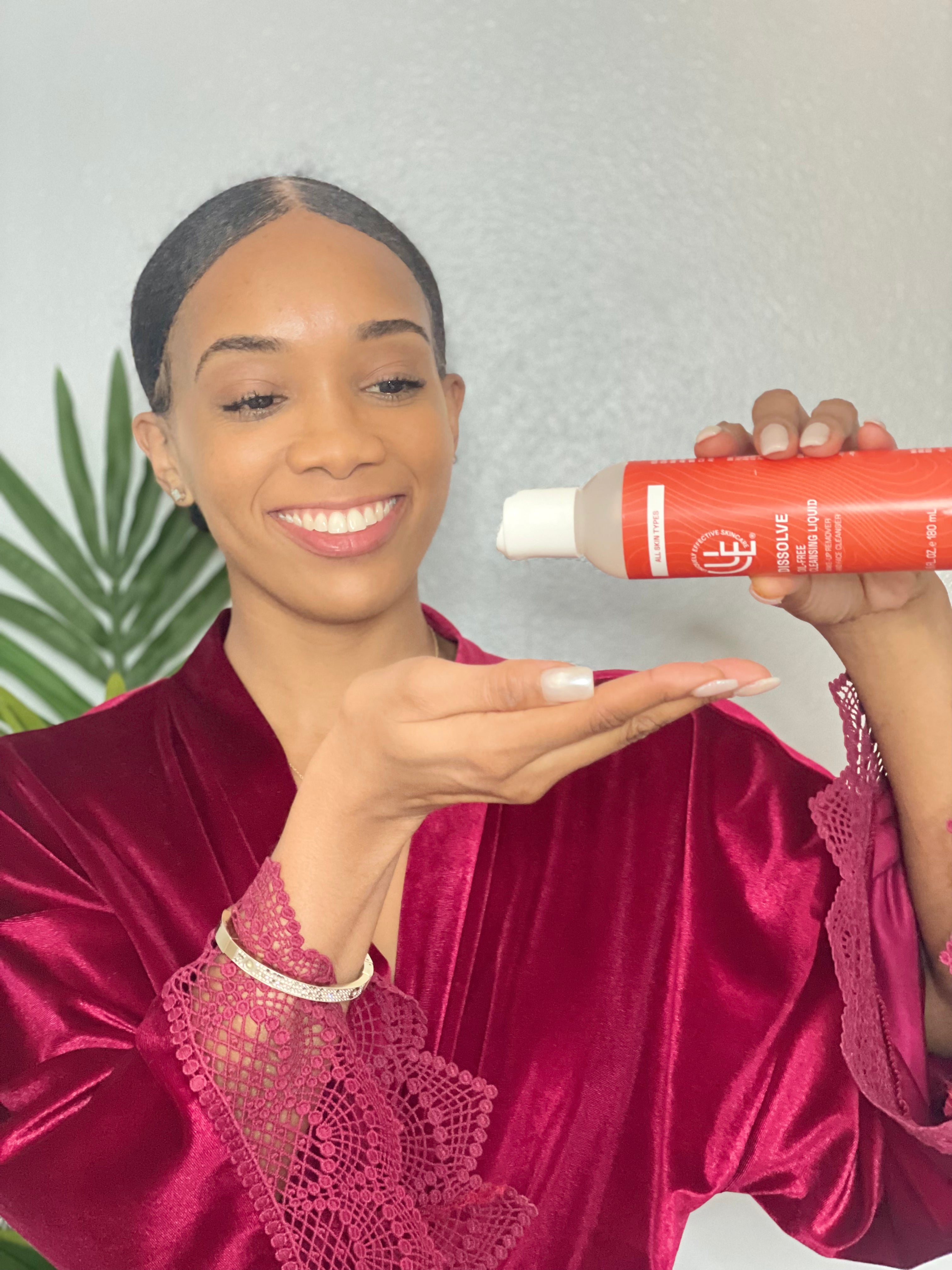 model pouring Uniquely Effective Skincare's Dissolve Oil-Free Cleansing Liquid Makeup Remover into her hand