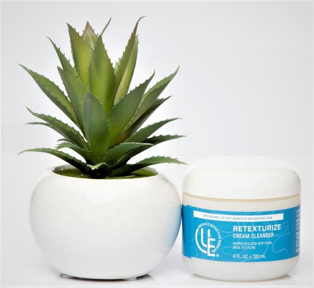 4 oz. fl. jar Retexturize Cream Cleanser Gentle Renewal sitting next to plant – hydrating cream cleanser with French sea waters, seaweed, and sugar exfoliants for mature, dry, and sensitive skin.