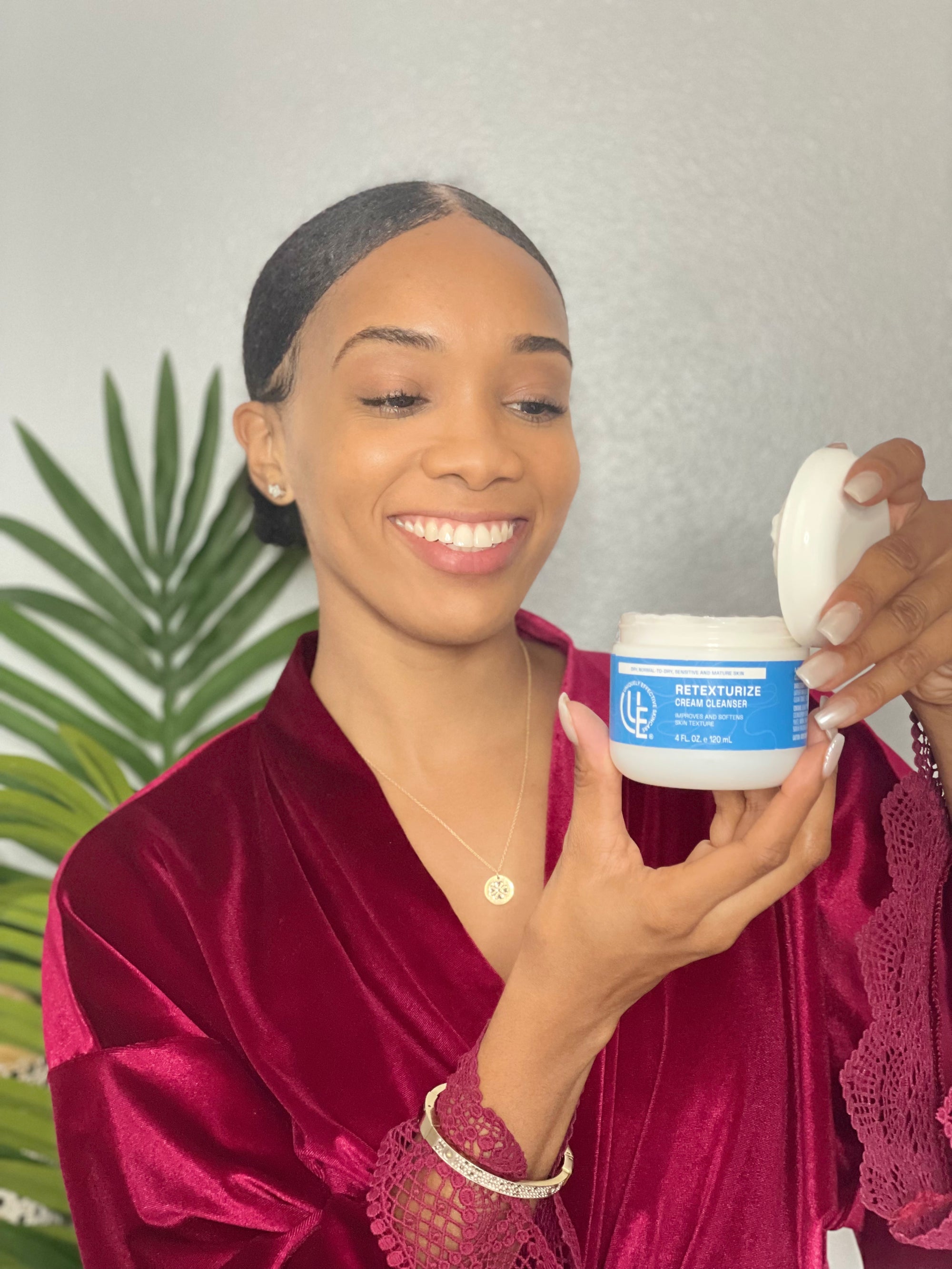 Picture of beauty woman with smooth and bright complexion holding an opened jar of Retexturize Cream Cleanser Gentle Renewal – hydrating cream cleanser with French sea waters, seaweed, and sugar exfoliants for mature, dry, and sensitive skin.