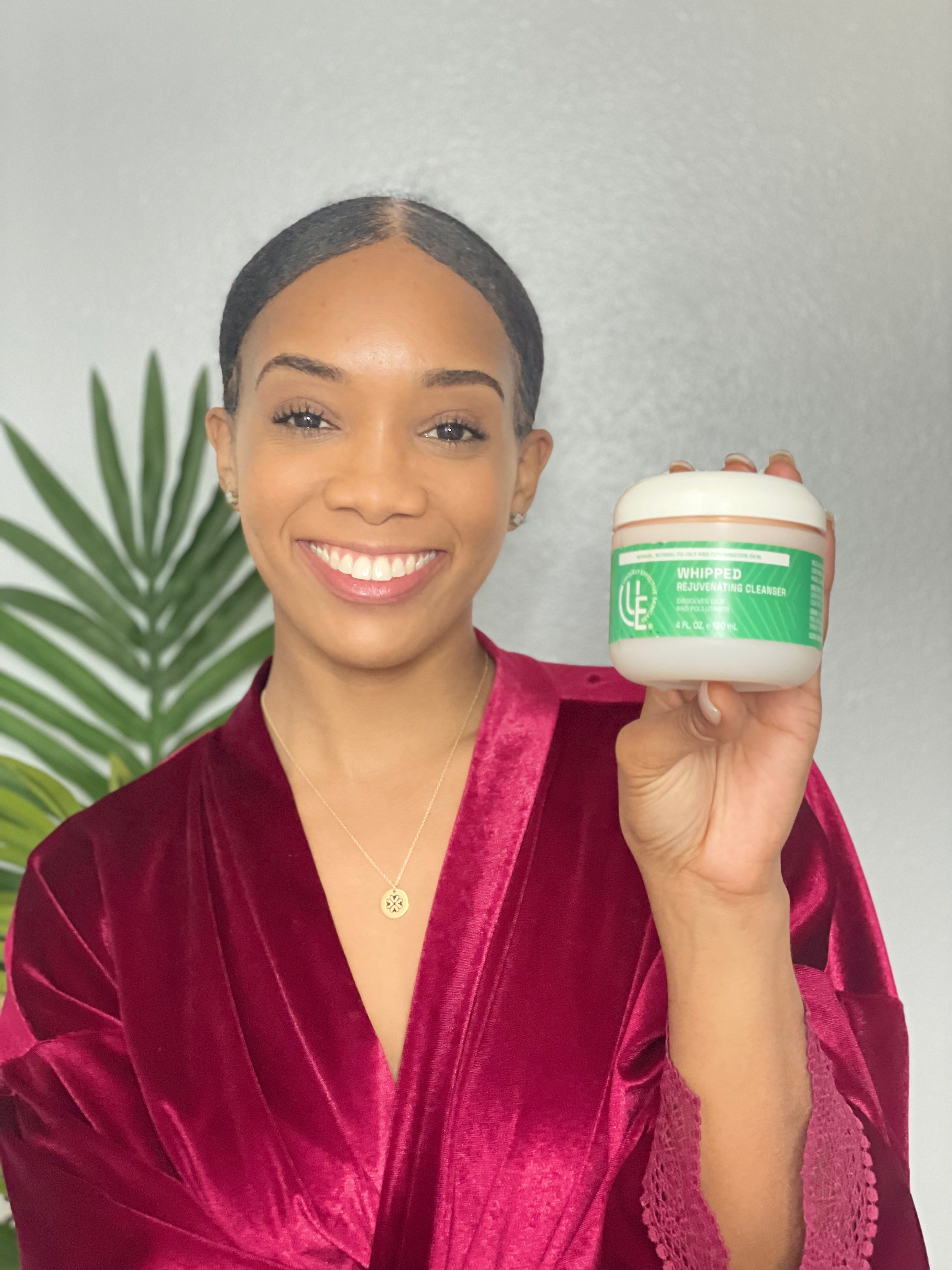 beautiful smiling Woman holding jar of  Whipped Rejuvenating Cleanser for normal, oily, and combination skin by Uniquely Effective Skincare