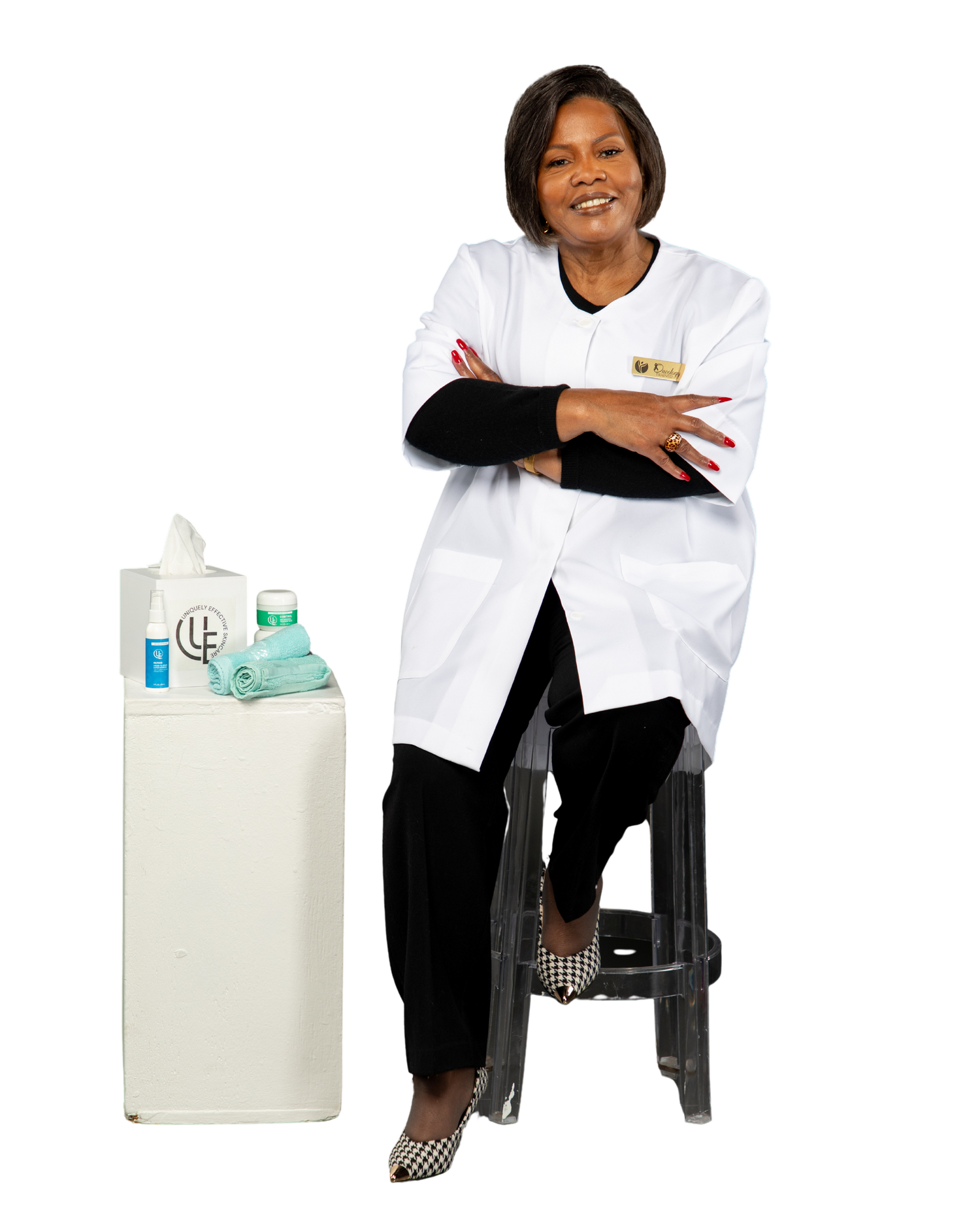 picture of owner of Uniquely Effective Skincare sitting on stool by her skincare products