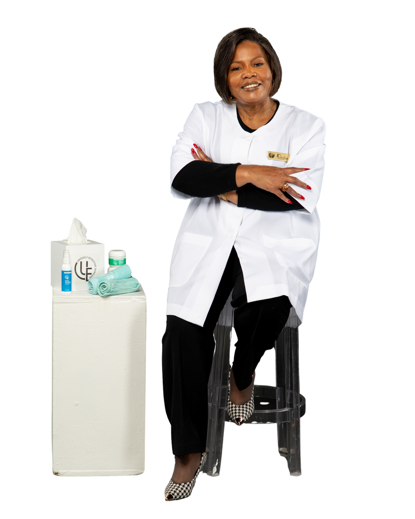 picture of owner of Uniquely Effective Skincare sitting on stool by her skincare products