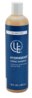 HydraMoist Crème Shampoo shown in a sleek 16 oz. bottle. The creamy, botanical-rich formula is being applied to textured 4C hair, highlighting its ability to deeply hydrate, soften, and balance the scalp. The shampoo creates a gentle lather while working through coily strands, helping to detangle and promote a smoother, healthier-looking finish.