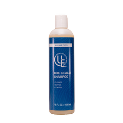 Coil & Calm Moisturizing Crème Shampoo shown in a sleek 16 oz. bottle. The creamy, botanical-rich formula is being applied to textured 4C hair, highlighting its ability to deeply hydrate, soften, and balance the scalp. The shampoo creates a gentle lather while working through coily strands, helping to detangle and promote a smoother, healthier-looking finish.