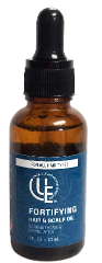 Amber glass bottle of Fortifying Hair & Scalp Oil from Uniquely Effective Skincare, shown with botanical ingredients to highlight its natural, nourishing formula.